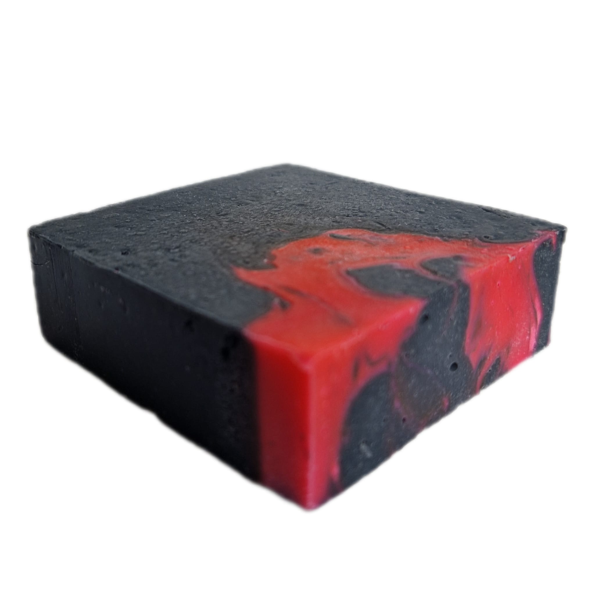 Vierkante zeepbar van opzij gezien, die schuin gedraaid ligt. Zwart en neonroze gemarmerd van kleur.