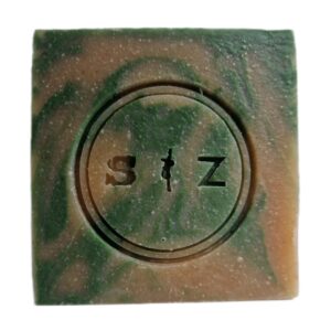 Vierkante zeepbar van voren gezien, lichtbruin en groen gemarmerd van kleur. In het midden van de zeep is een rond logo gestempeld met de tekst 's & z'.