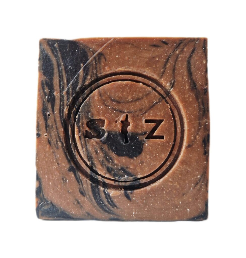 Vierkante zeepbar van voren gezien. De kleur van de zeep is chocoladebruin met een zwarte swirl.